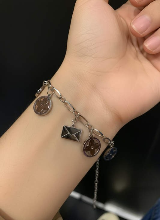 Pulsera de acero inoxidable en color plateado , con dijes - cristal